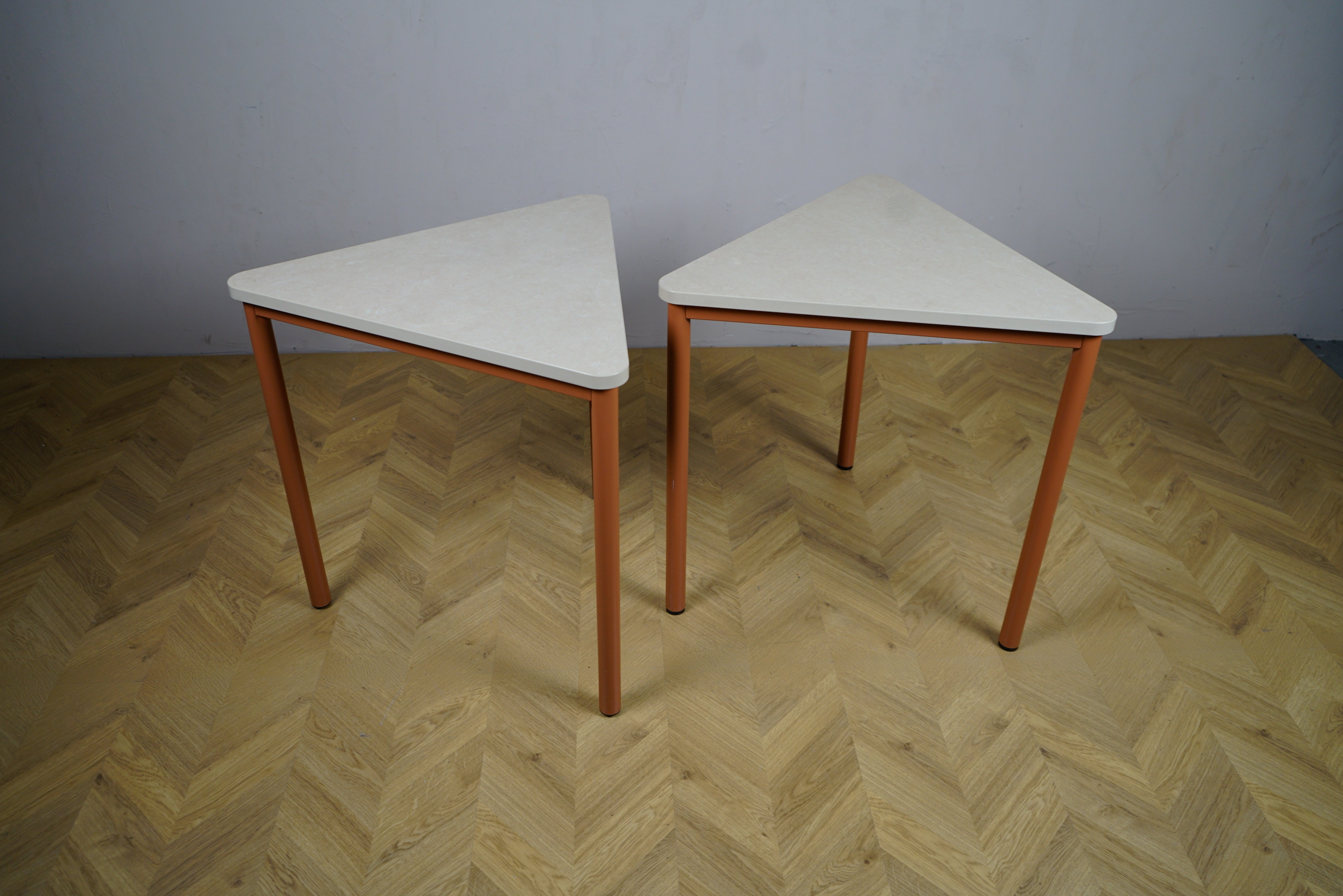 Kinnarps sæt af trekantede spiseborde i marmoleum beige set forfra – moderne spisebord, cafebord eller mødebord i skandinavisk design.